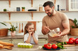 © Valerii Apetroaiei - Father and daughter bonding while cooking with fresh ingredients in the kitchen