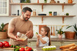 © Valerii Apetroaiei - Father and daughter bonding while cooking with fresh ingredients in the kitchen