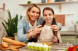 © Valerii Apetroaiei - A mother and daughter bond while baking in their kitchen, enjoying the activity together