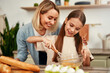 © Valerii Apetroaiei - A mother and daughter bond while baking in their kitchen, enjoying the activity together