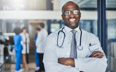 Canvas Print - Doctor, happy and confidence in hospital for healthcare, wellness or medical experience with stethoscope. Black man, smile and portrait in health facility with crossed arms for cardiology or medicine