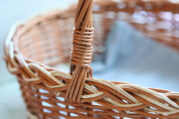 Poster - A close-up view of a traditional wicker basket on a wooden table.