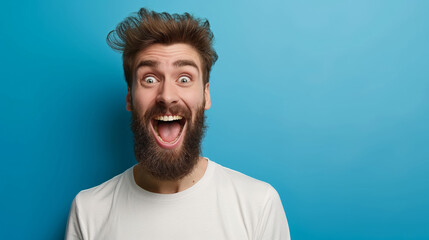 Wall Mural - A man with a beard and a white shirt is smiling and laughing. He has a big smile on his face and his eyes are wide open. Concept of happiness and joy