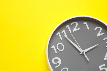 Wall Mural - Large round wall clock on yellow background