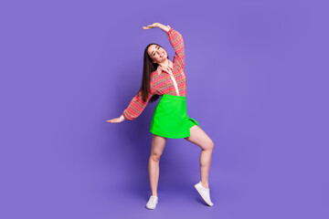 Wall Mural - Full length photo of lovely young lady dancing have fun dressed stylish pink garment isolated on violet color background