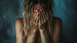© wasan - Woman crying in a dark room, covering her face with her hands