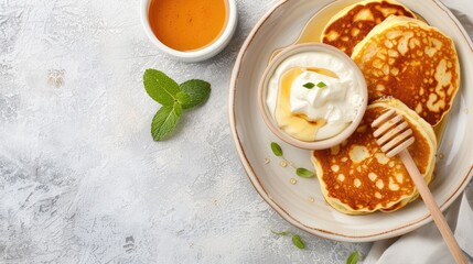 Wall Mural - Top view of a plate of crispy potato pancakes with sour cream and parsley, ready to be enjoyed