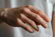 © Iryna - Close-up of a man's hand with manicure with clear nail polish.