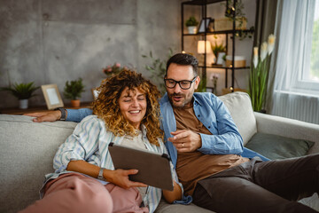 Adult couple use tablet at home have fun together