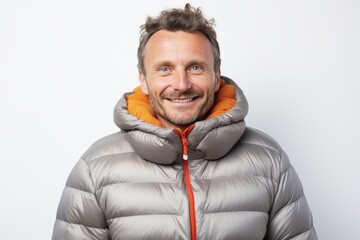 Wall Mural - Portrait of a smiling man in his 40s dressed in a thermal insulation vest isolated in white background