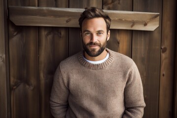 Sticker - Portrait of a happy man in his 30s wearing a cozy sweater isolated in rustic wooden wall