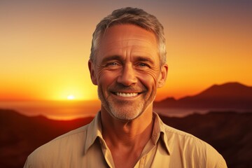 Wall Mural - Portrait of a grinning man in his 60s wearing a simple cotton shirt isolated on vibrant sunset horizon
