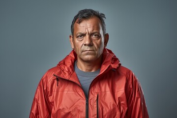 Wall Mural - Portrait of a merry indian man in his 50s wearing a lightweight packable anorak in modern minimalist interior