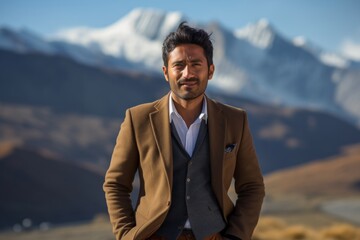 Sticker - Portrait of a jovial indian man in his 30s dressed in a stylish blazer while standing against backdrop of mountain peaks