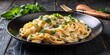 © lovetnihouse - Plate of creamy fettuccine Alfredo with herbs.