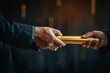 © Yuliia - close-up photo of a businessman passing a golden relay baton to his colleague, symbolizing teamwork and continuous support in the business world.