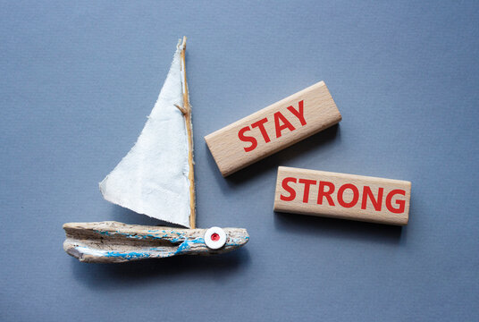 Stay Strong symbol. Concept word Stay Strong on wooden blocks. Beautiful grey background with boat. Business and Stay Strong concept. Copy space