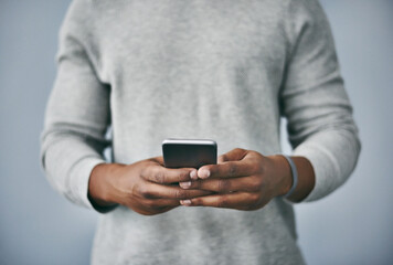 Aufkleber - Hands, typing and man with phone in studio for email, contact or text on internet connection. Scroll, smartphone and person on mobile app for online chat, social media or web post on grey background