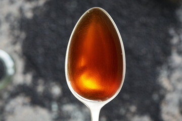 Poster - Black cumin or Nigella sativa seed oil on a spoon. Healthy anti-inflammatory and antioxidant supplement.