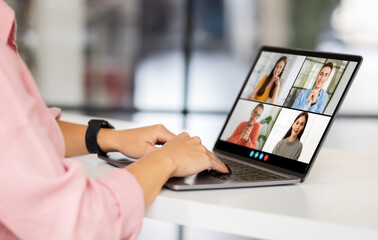 Aufkleber - A woman wearing a pink shirt sits at a desk and uses a laptop to participate in a virtual meeting with four other people on a video call.