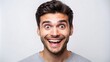 © Adisorn - Young man with raised eyebrows and genuine smile, showing teeth, looking directly at the camera in total surprise on a clean white background.