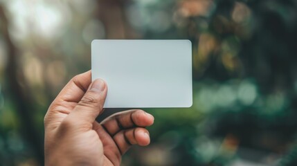 Hand holding white rectangular card with space for text