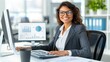 © lililia - A woman in a business suit sits at her desk working on a computer with data analysis displayed on the screen