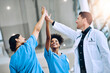 © ClearConcept/peopleimages.com - High five, doctors and smile for celebration, team unity and celebrate medical goals in clinic. Healthcare, happy group and people join hands for success, support and collaboration of diversity