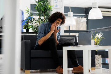 Wall Mural - Young arab business manager suffering from toothache in start up office. Company employee having tooth pain while working at strategy on laptop in corporate coworking space