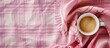 © Ilgun - Top view of a backdrop featuring a pink plaid pattern and a cup of coffee, laid flat with space for text or images in the shot. Copy space image. Place for adding text and design