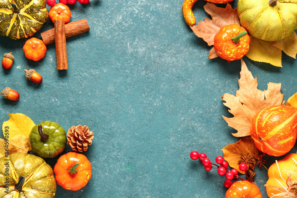 Autumn composition with ripe pumpkins, berries, spices and fallen leaves on blue background