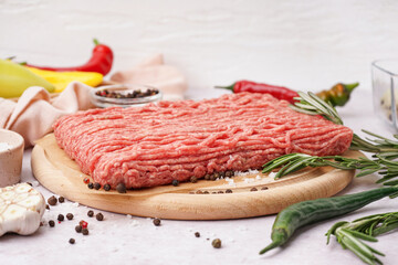 Wall Mural - Wooden board of fresh minced meat with spices on white background