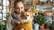 © evgenia_lo - A Caucasian woman holding a Chihuahua in a yellow sweater, both indoors surrounded by plants and kitchen items.