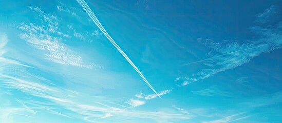 Poster - Clear blue sky with a white plane trail, providing copy space image from a bottom view, showcasing the concept of jet trails in the sky.