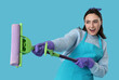 © Pixel-Shot - Cheerful woman with mop on blue background
