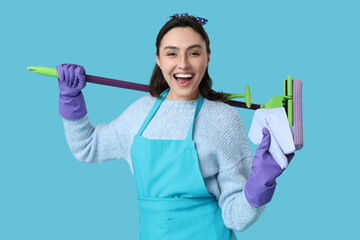 Wall Mural - Cheerful woman with mop and rag on blue background