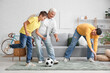 © Pixel-Shot - Family playing football in living room