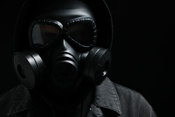 Wall Mural - Man in gas mask on black background, closeup