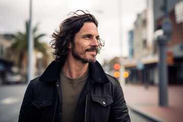 Portrait of a handsome man with long wavy hair in a urban context