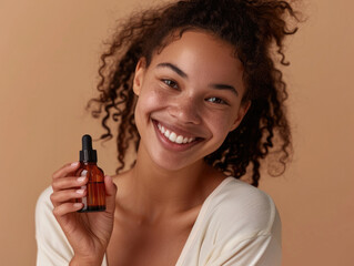 Wall Mural - A woman is holding a bottle of perfume and smiling. The bottle is brown and has a black cap. The woman's hair is curly and she has a bright smile on her face