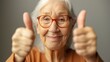 © Todd's Studio - Beautiful senior woman showing thumbs up with both hands, elderly care, positive life attitude of seniors