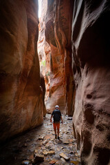 young man walking through a scenic slot canyon near zion national park in utah. hiking adventure in 