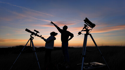 Wall Mural - amateur astronomers looking at the evening skies, observing planets, stars, moon and other celestial