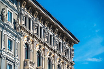 Wall Mural - Historic city of Trieste. Between ancient buildings and reflections on the sea. Autumn day and celebration of the Barcolana International Regatta.