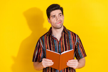 Poster - Portrait of nice young man book look empty space wear shirt isolated on yellow color background