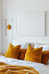 Wall Mural - A close-up shot of a white wall with an empty picture frame. The room is decorated in a modern style and has mustard-yellow velvet pillows on the bed. The photo was taken from above.