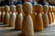 © Ray - Close-up of wooden figure pawns in rows on a table, one with unique features, and copy space for text, symbolizing diverse business people.