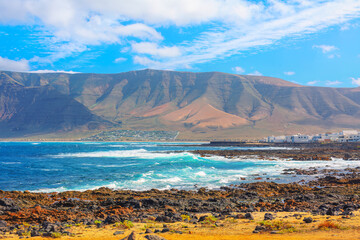 Wall Mural - Beautiful mountain range with a blue ocean in the background. Volcanic scenery of Famara from Lanzarote, Canary Islands