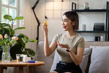 Young Woman Taking Medication at Home, Emphasizing Modern Healthcare and Wellness in a Cozy Living Room Setting