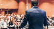 © kasto - Speaker at Business Conference with Public Presentations. Audience at the conference hall. Entrepreneurship club. Rear view. Horisontal composition. Background blur.
